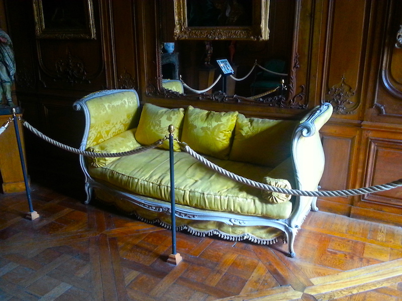 A yellow-upholstered lit de travers, or daybed, in the Carnavalet Museum.